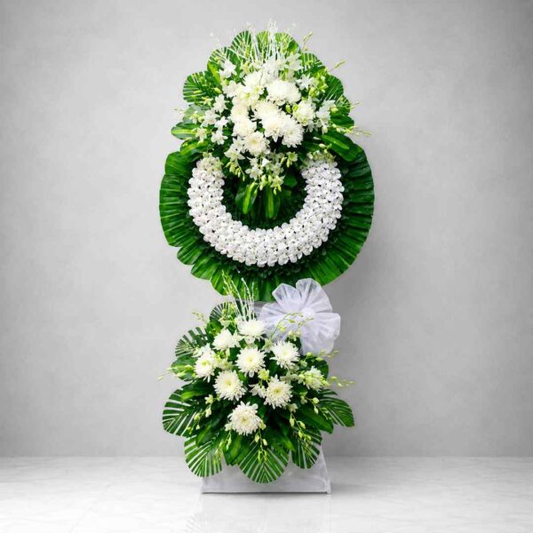 Kệ hoa chia buồn 529 tông trắng sang trọng với vòng hoa lan trắng kết hợp cúc trắng, lá xanh đậm, thiết kế trang nhã và trang nghiêm.