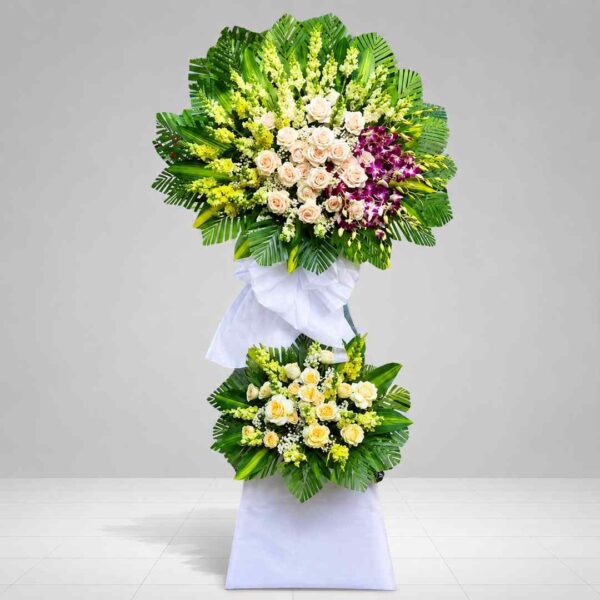 Lẵng Hoa Chia Buồn Lời Tiễn Cuối 496 với thiết kế 2 tầng sang trọng, kết hợp hoa hồng kem, lan tím, hoa trắng và lá xanh, gửi lời tiễn biệt đầy thành kính.