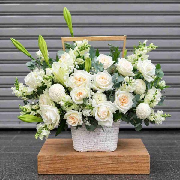 Giỏ hoa viếng 483 với hoa hồng trắng, hoa ly trắng và cúc trắng được cắm trong giỏ xách thanh lịch