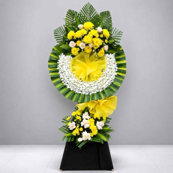 Kệ hoa chia buồn 454 với thiết kế hai tầng sang trọng, vòng hoa trắng kết hợp hoa cúc vàng và hoa hồng kem, tượng trưng cho sự tiếc thương, kính viếng và chia sẻ mất mát.