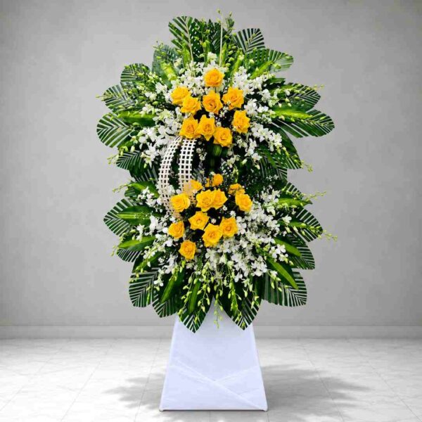 : Kệ hoa chia buồn 487 với hoa hồng vàng nổi bật kết hợp hoa lan trắng và lá xanh nghệ thuật, thiết kế sang trọng thể hiện sự kính trọng và tiếc thương