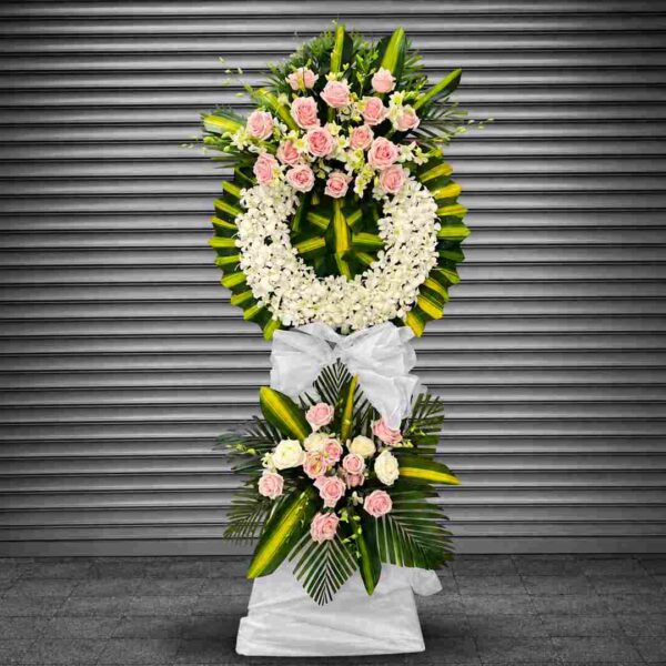 Kệ hoa chia buồn 528 với vòng hoa lan trắng kết hợp hoa hồng phấn, lá xanh nghệ thuật và chân kệ phủ vải trắng trang nhã, thể hiện sự kính trọng và tiếc thương sâu sắc.