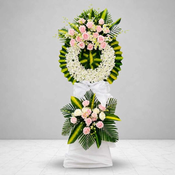 Kệ hoa chia buồn 528 với vòng hoa lan trắng kết hợp hoa hồng phấn, lá xanh nghệ thuật và chân kệ phủ vải trắng trang nhã, thể hiện sự kính trọng và tiếc thương sâu sắc.